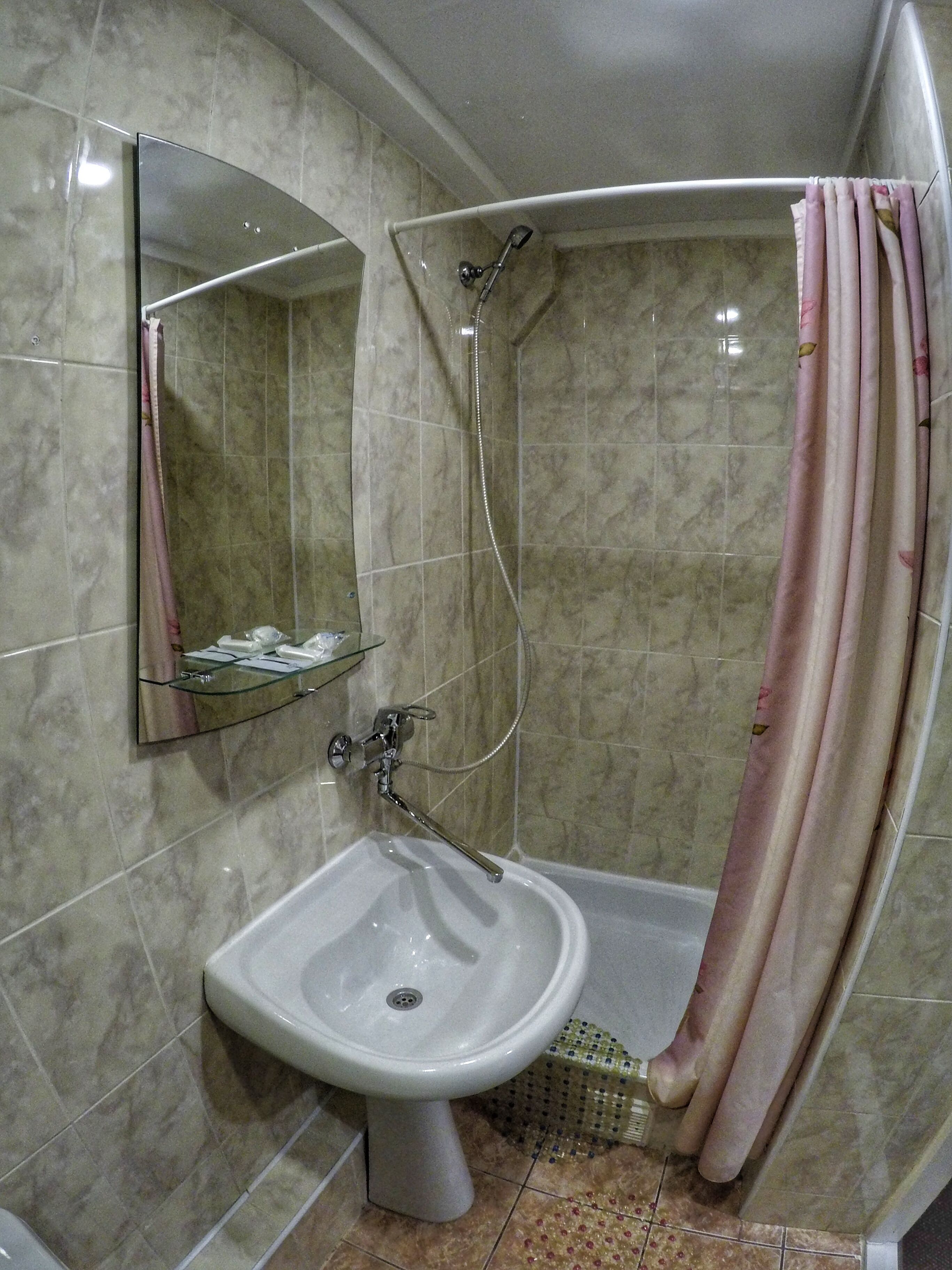 Un bagno con doccia, lavandino e specchio.
