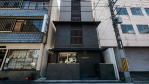 Un hotel con fachada moderna, entrada visible y un cartel que indica que es un hotel.