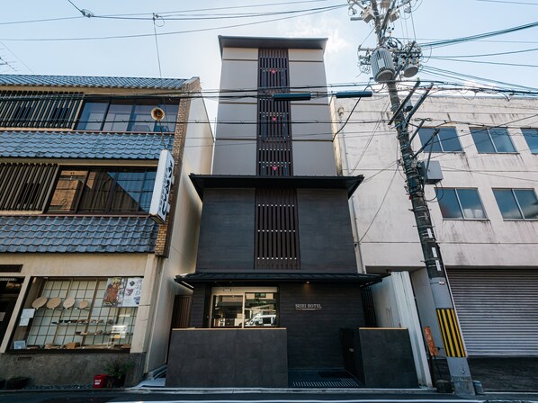 A hotel with a modern facade, a visible entrance, and a sign indicating it is a hotel.