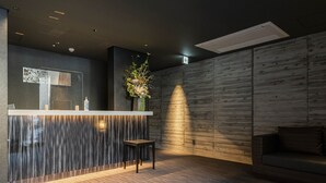 Una moderna zona de recepción con pared de madera, un mostrador de recepción y un área de estar.