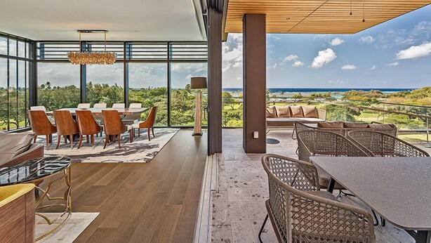 Una habitación amplia con una gran mesa de comedor, asientos cómodos y vistas al océano.