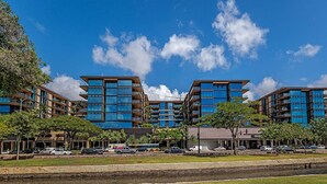 Un hotel moderno con varios edificios altos, un estacionamiento y una zona ajardinada.