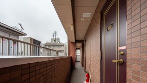 En korridor med en rød dør med teksten '803' og en brandslukker på gulvet.