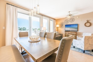 Relax in this spacious living area with a large dining table and comfortable seating, perfect for unwinding with a view of the outdoors.
