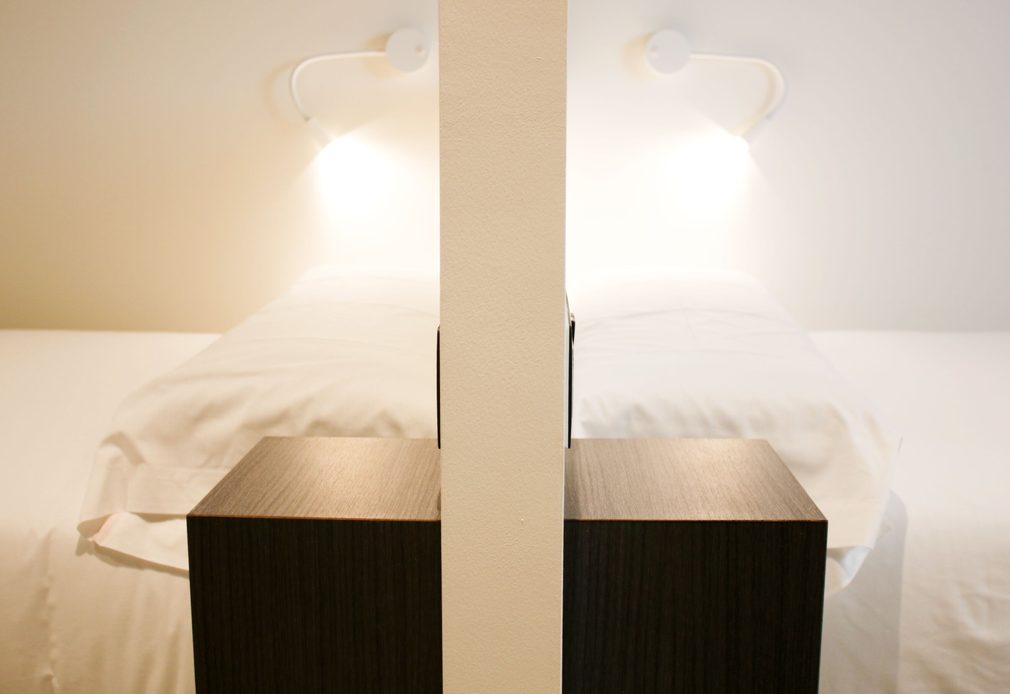 Een bed met een houten hoofdbord en een nachtkastje.