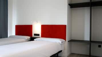 Habitación de hotel con dos camas, cabecero rojo, mesita de noche y estante de pared.