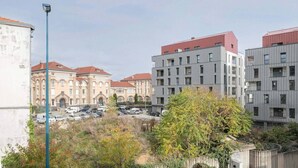 A modern apartment building with a parking lot in front.