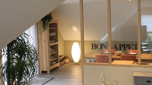 A modern interior with a dining area, wooden shelving, and a large mirror reflecting the room. - Au NEUF MILLE, luxury apartment **** 2 steps from the port of Perros-Guirec (Perros-Guirec)