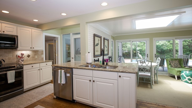 A kitchen with white cabinets, a stainless steel refrigerator, and a granite countertop. - 4 Bedroom Pinehurst Home with Pool and Hot Tub (Pinehurst)
