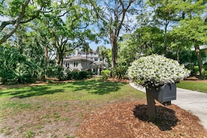 A residential property with a well-maintained lawn, mature trees, and a mailbox. - Stunning home close to the Ocean Course (Johns Island)