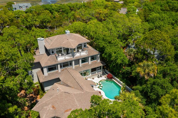 A large, two-story house with a swimming pool surrounded by dense trees. - Stunning home close to the Ocean Course (Johns Island)