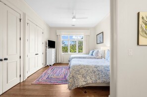 A bedroom with two beds, a TV, a window, and a ceiling fan. - Stunning home close to the Ocean Course (Johns Island)