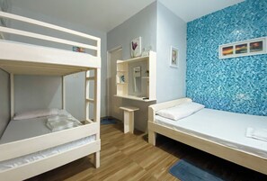 A room with bunk beds, a desk, a mirror, and a blue textured wall. - Urbanview @ Bnky Bed And Breakfast Palawan (El Nido)