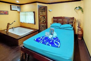 A bedroom with a bed, a wooden headboard, a window with a curtain, a bedside table with a vase, and a wall-mounted air conditioner. - Urbanview @ Bnky Bed And Breakfast Palawan (El Nido)
