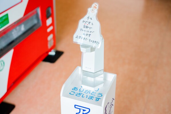A vending machine with Japanese text and a logo.