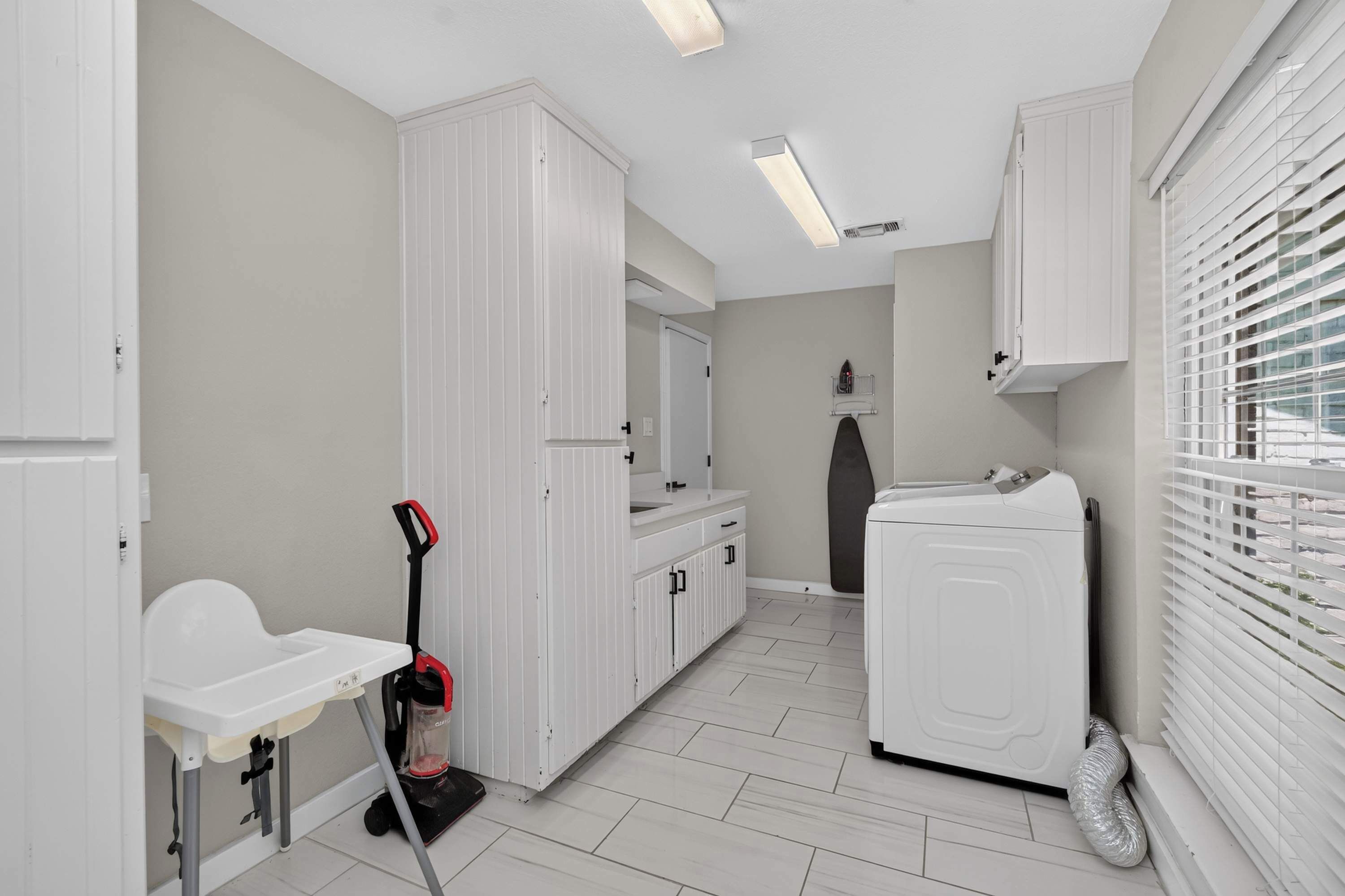 A modern bathroom with a white sink, cabinet, and shower.