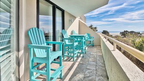 A balcony with turquoise chairs and a view of the ocean. -  Golfers Welcome, South Tower-Ocean Creek-1st Floor-Spacious Condo,Openings (Myrtle Beach)