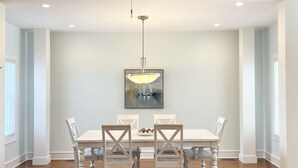 A dining area with a white table and chairs, a ceiling fan, recessed lighting, and a framed artwork on the wall. - Luxury Sea Bright Home, Ocean Views, 6 Sun Decks! (Sea Bright)