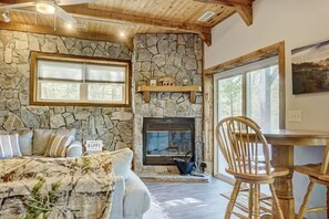 Cozy space with a fireplace, sofa, and dining table.