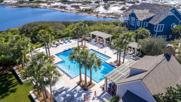 A resort with a swimming pool, lounge chairs, and a view of the ocean. - Family Retreat with Pool and Golf Cart (Watersound)