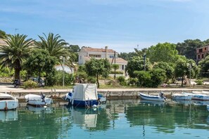 A marina with boats docked, surrounded by trees and buildings. - Beachfront Holiday House Kaliope (Brgulje)