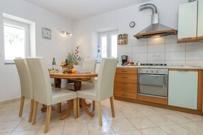 Una cocina moderna con una mesa de comedor, sillas, estufa y horno empotrado.