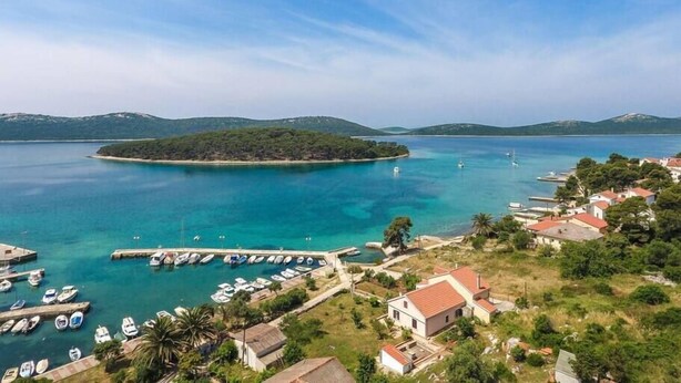 A coastal village with a marina, houses, and a small island. - Beachfront Holiday House Zita (Brgulje)