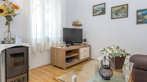 A living room with a fireplace, television, wooden furniture, and wall art. - Beachfront Holiday House Zita (Brgulje)