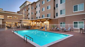 Una piscina al aire libre, sillones reclinables de piscina