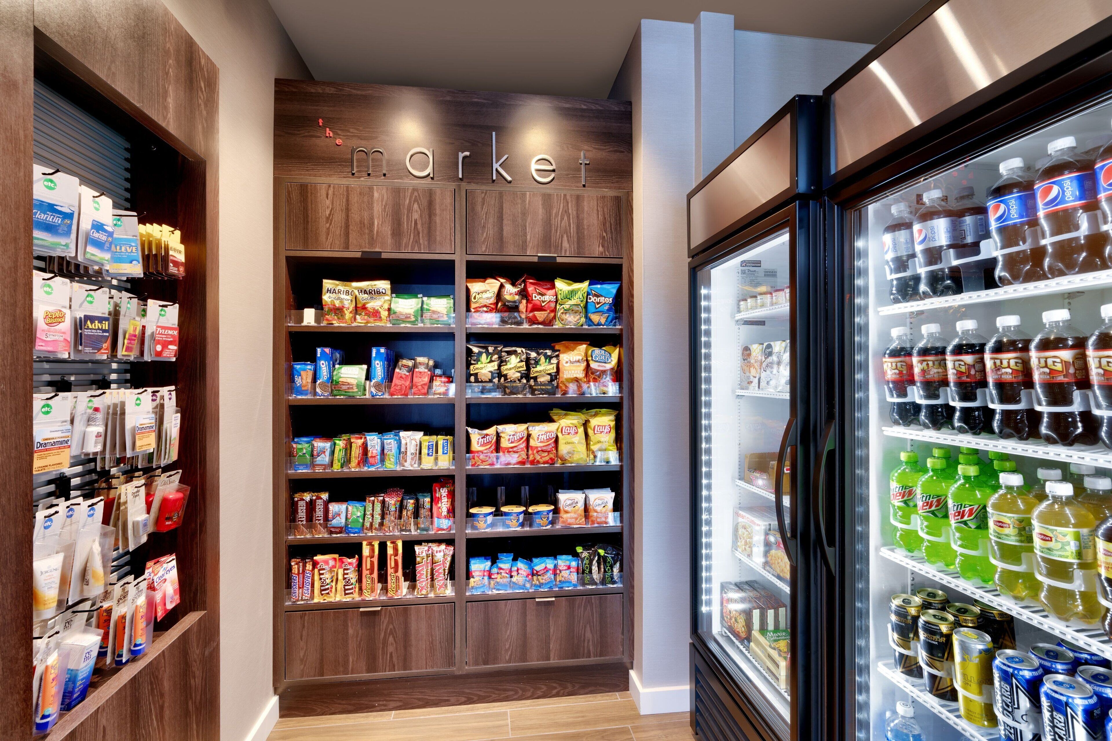 A grocery store with shelves stocked with snacks, beverages, and household items.