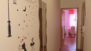 Un couloir avec un mur recouvert de miroirs, une illustration de chat et un panneau portant le mot « Amour ».