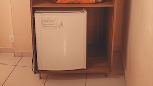 A wooden wardrobe with a small refrigerator at the bottom. - Hotel Piracicaba (Aparecida)