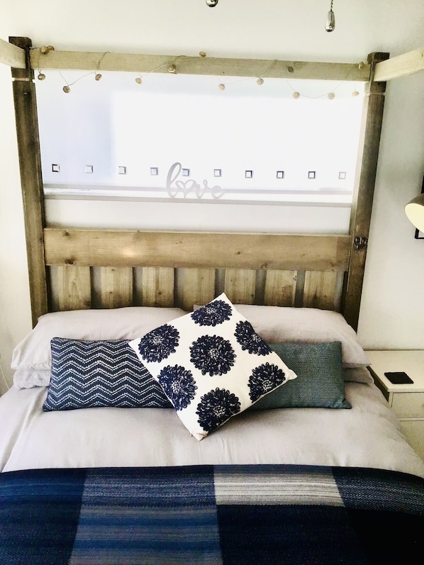 Cozy retreat with a comfortable bed, adorned with decorative pillows and ambient lighting.