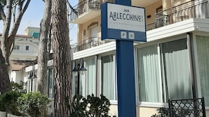 Un bâtiment avec une enseigne indiquant « ARLECCHINO » et un symbole de stationnement.