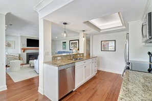 Enjoy cooking in this well-equipped kitchen with a central island, stainless steel sink, and dishwasher.