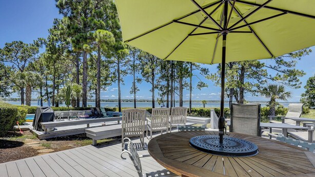 Une terrasse avec des meubles d’extérieur, une table et un parasol.