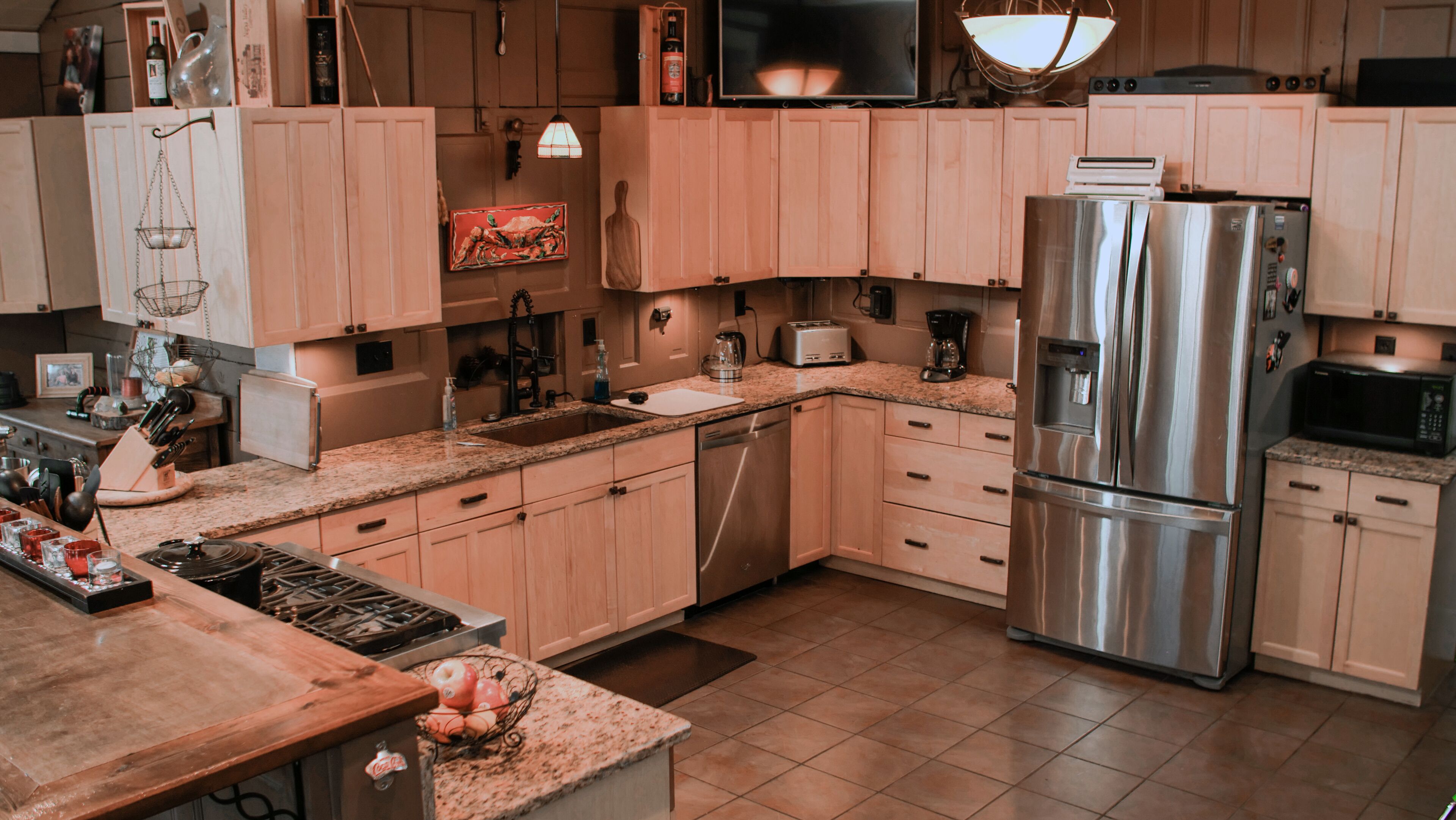 A modern kitchen with wooden cabinets, stainless steel appliances, a granite countertop, and a built-in oven.