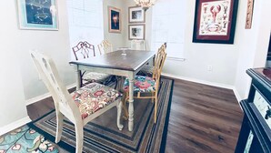 A dining area with a wooden table, chairs, and a chandelier. - 2 Beach view Cottages, Perfect family get together (Gulfport)