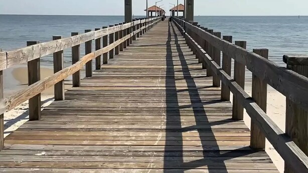 A wooden pier leading to a sign reading "Libby Miller Roland Municipal Pier." - 2 Beach view Cottages, Perfect family get together (Gulfport)