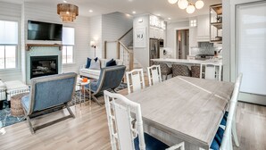 Una cocina moderna con muebles blancos, horno integrado y refrigerador de acero inoxidable.
