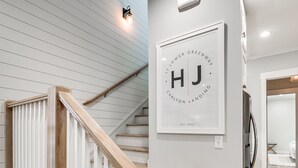 Una escalera con barandillas de madera y un aplique en la pared.