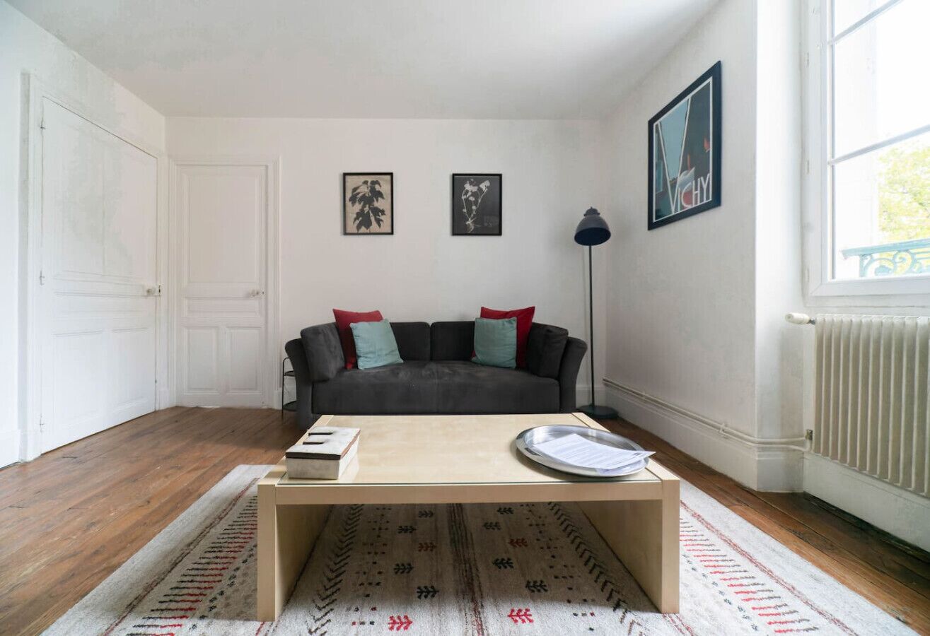 Una sala de estar con un sofá, una mesa de centro y un radiador.