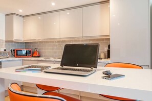 A modern kitchen with white cabinets, a white countertop, and a laptop. - Magnificent views of Tamar and Rwy. Free Parking (Plymouth)
