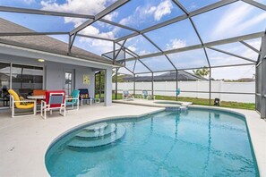 Ein überdachter Pool mit Liegestühlen und einer Terrassenfläche.