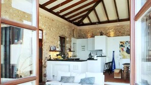 A cozy living area with a white sofa, a coffee table, and a kitchen in the background.