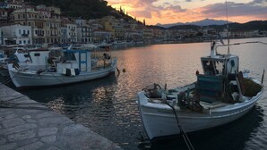 A harbor with boats docked, a stone quay, and buildings in the background.