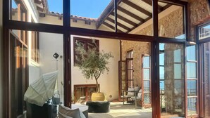 A spacious patio with a seating area, a potted tree, and a view of the outside.