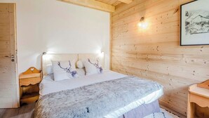 Un dormitorio con paneles de madera, una cama, mesitas de noche y un cuadro en la pared.