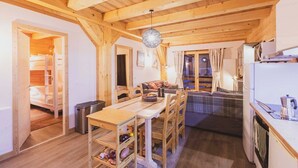 Un interior de madera con comedor, cocina y un rincón de estar acogedor.