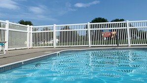 A swimming pool with a white fence and a warning sign. - Beautiful beach bliss (Ocean View)